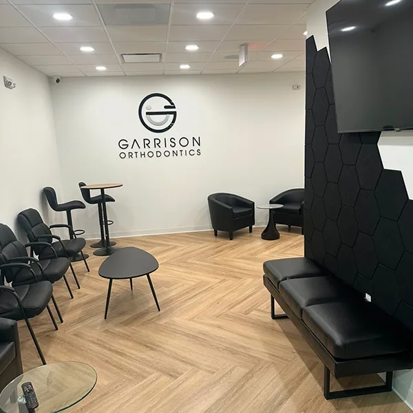 A clean, modern treatment room equipped with an orthodontic chair and care station.