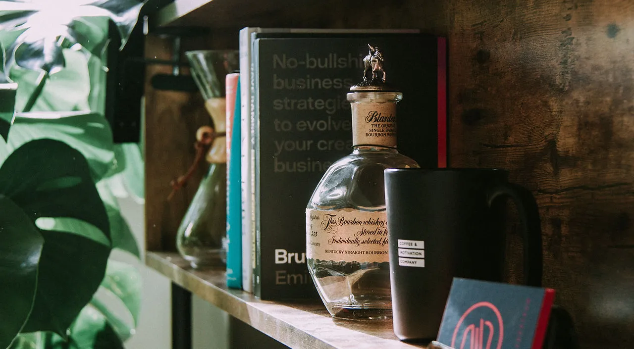 A styled bookshelf featuring books and a mug, moody atmospheric lifestyle shot