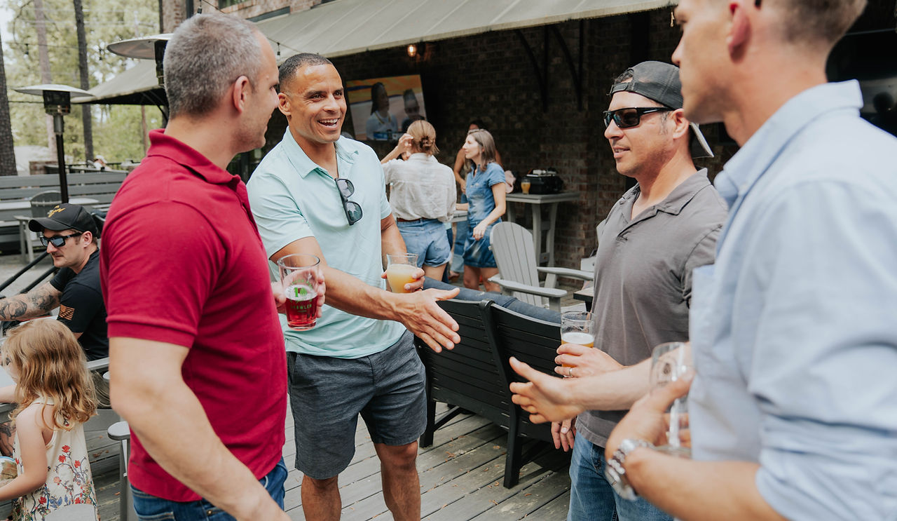 Guests talking and shaking hands on an outdoor deck