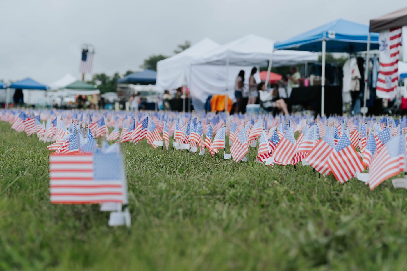 Rows of small American flags in front of event tents