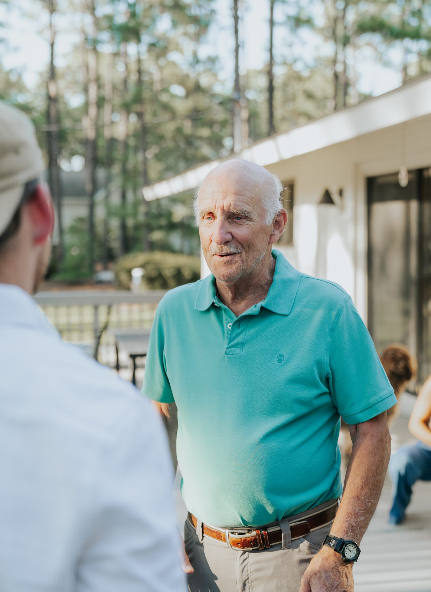 A veteran in conversation on a porch at a Rural Salute event